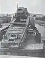 A rear view of a damaged gun showing the traversing rail
