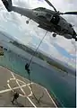 A member of an Algerian navy boarding team fast-ropes out of a Hellenic Navy S-70B-6 Aegean Hawk helicopter assigned to the 2nd Squadron onto the training ship Aris (A 74) at the NMIOTC