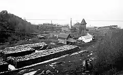 Image of the Angeles brewery, some time between 1901 and 1915.  A large stack of cordwood is near the structure.