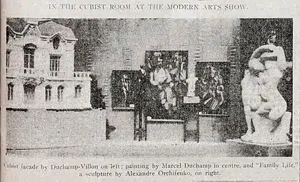 Installation shot of the Cubist room, published in the New York Tribune, February 17, 1913 (p.&nbsp;7). Left to right: Raymond Duchamp-Villon, La Maison Cubiste (Projet d'Hotel), Cubist House; Marcel Duchamp Nude (Study), Sad Young Man on a Train; Albert Gleizes, L'Homme au Balcon, Man on a Balcony; Marcel Duchamp, Nude Descending a Staircase, No. 2; Alexander Archipenko, La Vie Familiale, Family Life