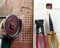100&nbsp;mm (4") angle grinder with diamond blade, with tiling snips being used to cut holes in tiles.