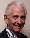  An old man in black suit and striped shirt, the whistleblower Daniel Ellsberg
