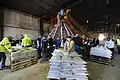 Manual filling with a conveyor belt and a 12 direction sandbag filler called "The Sandbagger" capable of filling over 5,000 sandbags an hour.