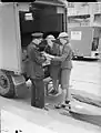 A police officer has his hand bandaged at the rear of an AAGB Austin K2/Y following a V1 attack in Upper Norwood, 1944.