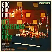 A piano, guitar, and amp covered in colorful Christmas lights