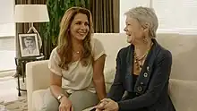 Two smiling women sitting together on a sofa