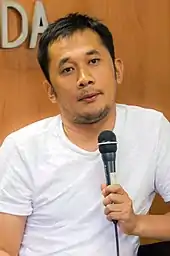 A man in a white shirt looking forward