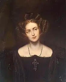 Young woman looking left with blonde curls in a black dress