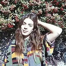 A photo of Byrne smiling in front of foliage