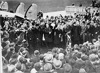 British Prime Minister Neville Chamberlain, landing at Heston aerodrome on 30 September 1938 after his meeting with Hitler at Munich. In his hand he holds the peace agreement between Britain and Germany.