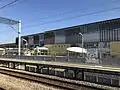 A view from the Kagoshima Main Line platform eastwards across the station forecourt towards the Shinkansen station.
