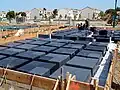 Wafflemat foundations like this one have covered over 25,000,000 sq ft (2.3 km2) of ground. They are built using void forms that allow the foundation to compensate for collapsible soils.