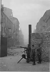 NARA copy #37, IPN copy #35Securing a streetMG08 at the gate on Nowolipie Street intersection with Smocza Street, looking East. In the back Nowolipie 56.